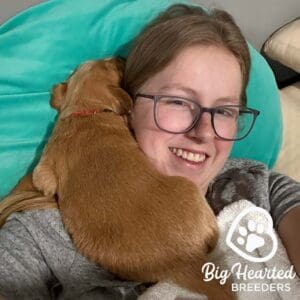 Woman cuddling with a mini Golden Retriever puppy