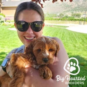 Woman holding a mini Golden puppy