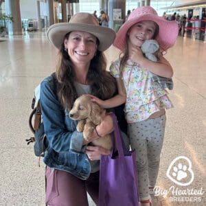 Young owners holding their new mini Golden puppy, wondering how to tell if their dog is in pain