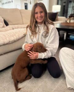 New owner holding her brown mini Golden puppy on her laps and wondering, "Why do dogs zoom?"