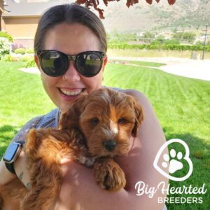 A woman holding a puppy in her arms and smiling