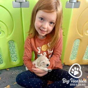 Young girl with red hair sitting with a puppy on her laps