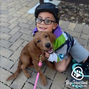 Young kid holding a mini Golden puppy, asking, "Do Dogs Really Smile"