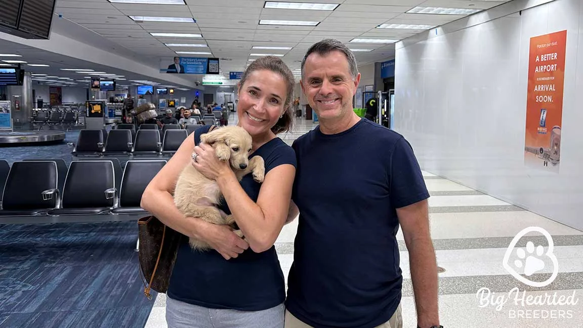 A couple holding their new puppy in their arms